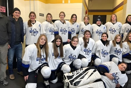 Un grupo de estudiantes del Lewisporte Collegiate posan en equipo de hockey juntos en el vestuario.