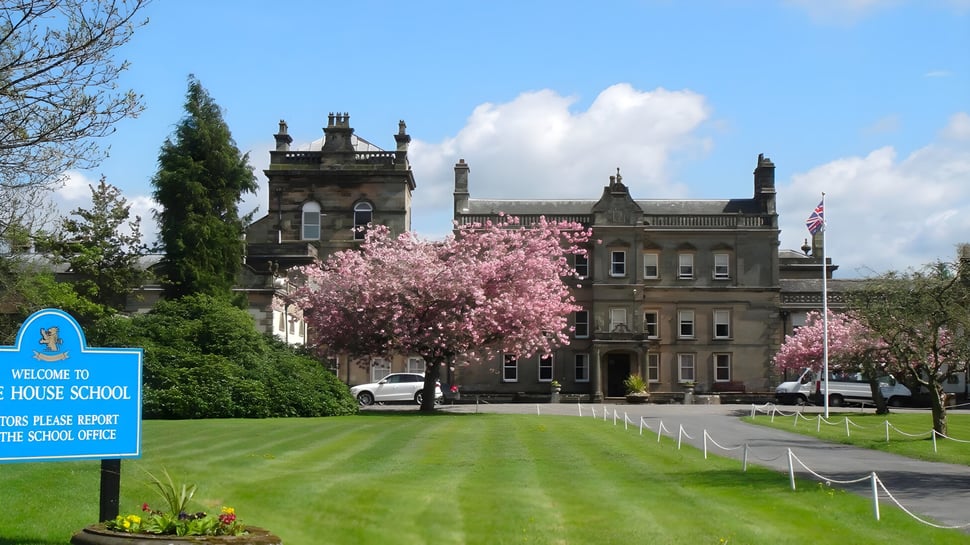 El histórico edificio principal de la Lime House School está rodeado de cerezos en flor y una zona de césped.