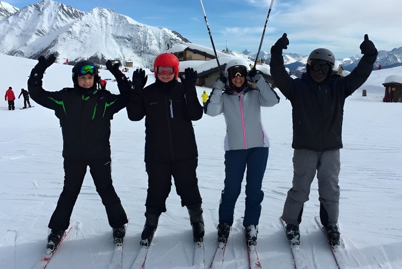 Un grupo de estudiantes de la Lime House School está de pie con esquís en un paisaje montañoso nevado.