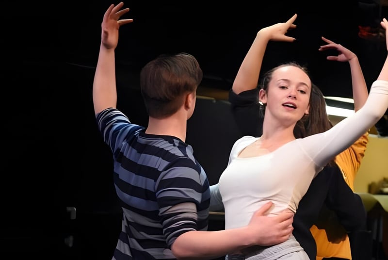 Dos personas bailan en el escenario durante un evento de la Lincoln Academy.