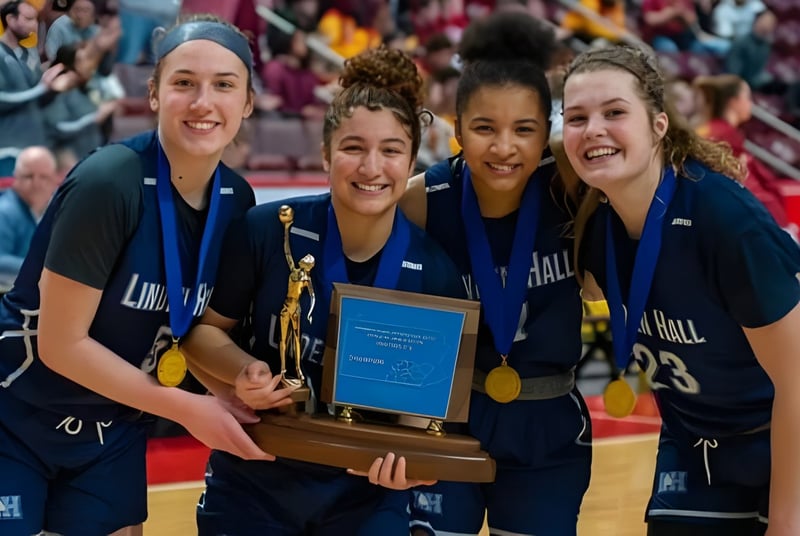 Cuatro estudiantes en uniformes azules de Linden Hall sostienen juntos un trofeo en una arena llena.