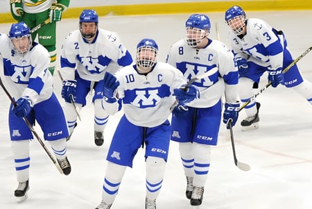 Estudiantes del Lisgar Collegiate Institute juegan hockey sobre hielo en la pista con una portería verde y amarilla.