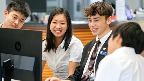 Estudiantes del Long Bay College trabajan juntos en una computadora en un entorno de aprendizaje.