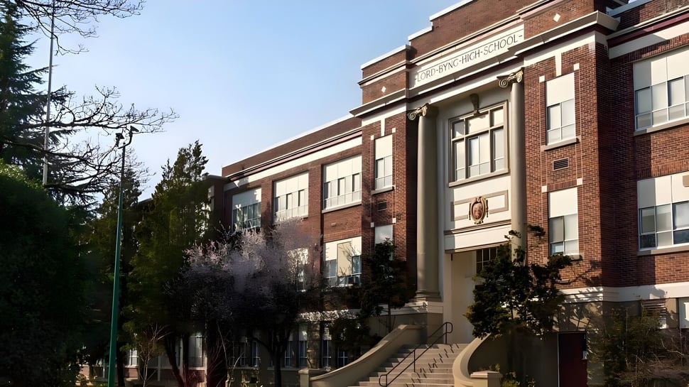 El edificio de ladrillo de varios pisos de la Lord Byng Secondary School está rodeado de árboles y áreas verdes.