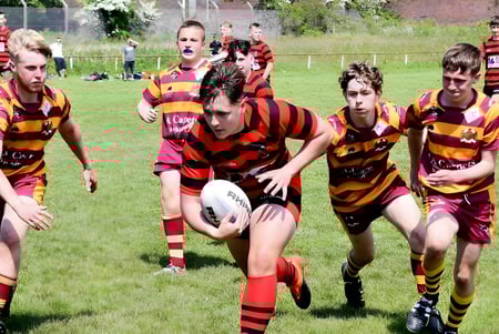 Un grupo de jugadores de rugby corre en el campo deportivo del Lord Wandsworth College durante un juego.