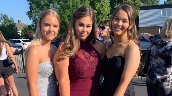 Cuatro alumnas de la Loreto High School Beaufort posan juntas al aire libre frente a una zona residencial.