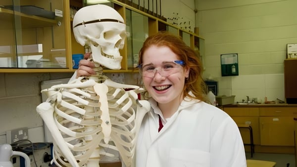 Una alumna de la Loreto Secondary School en Cork está junto a un modelo de esqueleto en el aula.
