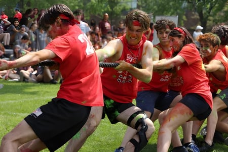 Un grupo de estudiantes lleva camisetas rojas y participa en una actividad animada en el exterior del Lower Canada College.