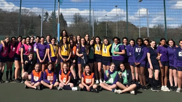 Un gran grupo de jóvenes alumnas en coloridos uniformes deportivos en el campo de deportes de LVS Ascot.