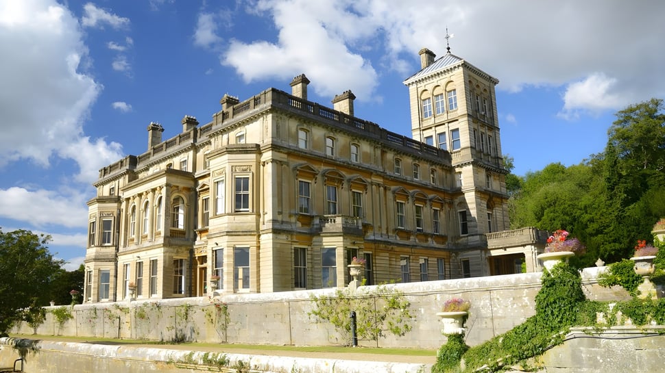 El magnífico edificio con arquitectura elaborada en el campus de LVS Ascot está rodeado de vegetación verde.