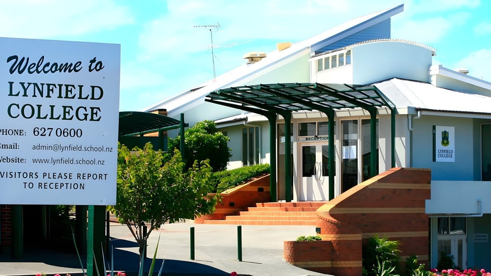 La moderna entrada con techo de vidrio y un área exterior bien cuidada en Lynfield College.