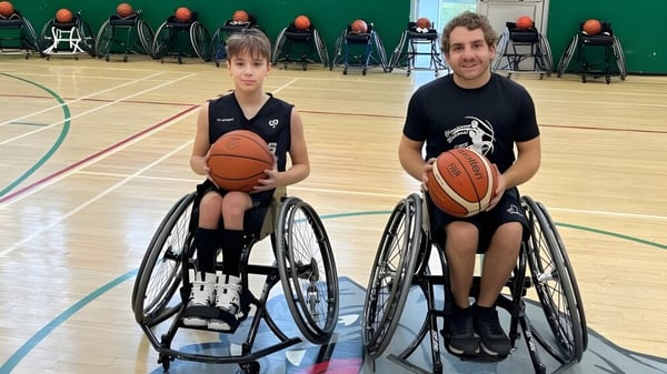 Dos estudiantes en sillas de ruedas juegan al baloncesto en el campo de la Macdonald High School.