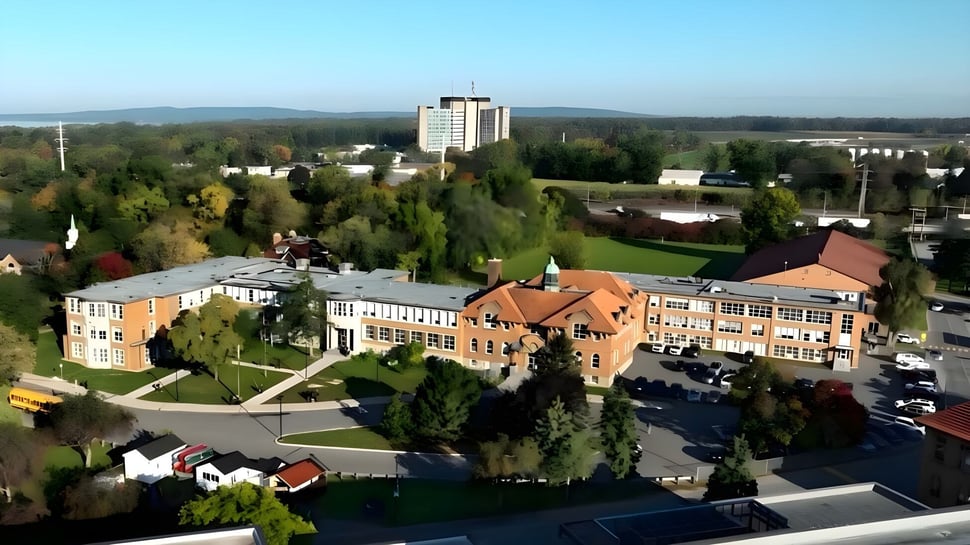 Imagen aérea del campus de la Macdonald High School con edificios modernos e históricos en medio de colinas verdes.
