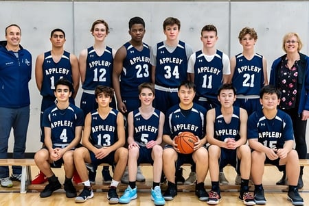 Un grupo de estudiantes del Appleby College posan en uniformes de baloncesto en un gimnasio.
