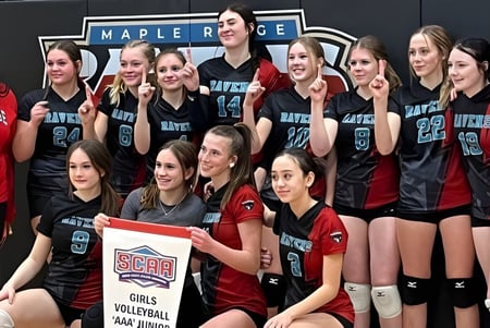 Un grupo de jugadoras de voleibol posan juntas frente al letrero de la Maple Ridge Secondary School en Ontario.