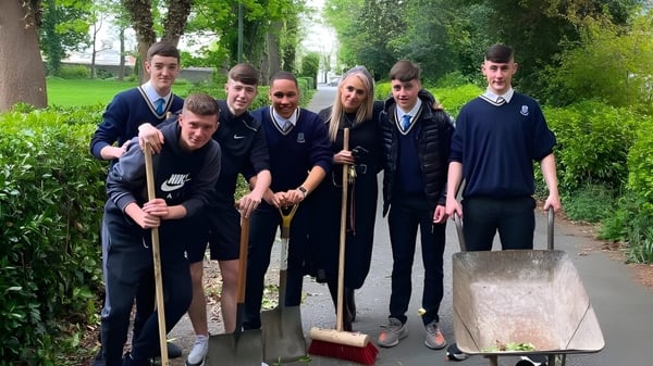 Los estudiantes del Marian College trabajan juntos en un proyecto de jardín en el área verde exterior.