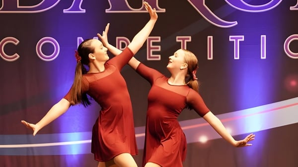 Dos bailarinas en vestidos rojos se presentan en un concurso de baile en el escenario de la Marianapolis Preparatory School.