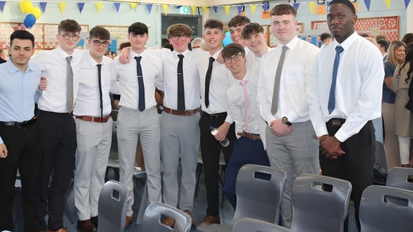 Un grupo de estudiantes en atuendo formal se encuentra juntos en un aula en el campus del Marist College.