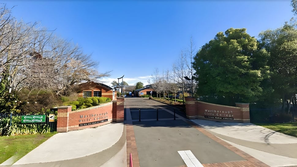 Un camino pavimentado lleva a través de un paisaje verde en el terreno de la Marlborough Girls School.