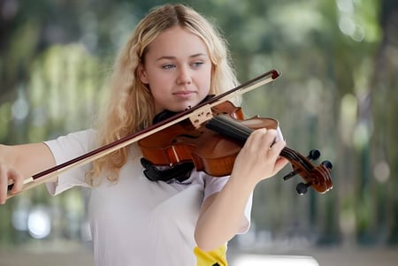 Una estudiante de la Maroochydore State High School toca el violín en el campo.