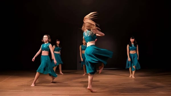 Tres bailarinas realizan una presentación en el escenario de la Marymount International School.