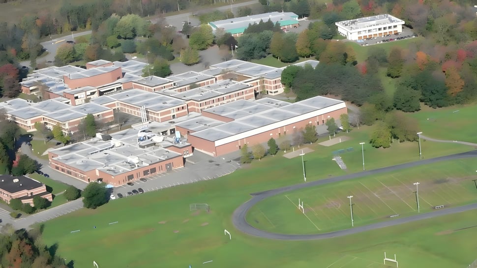 El extenso campus de la Massey-Vanier High School está rodeado de árboles y se encuentra junto a una gran área verde con una carretera de acceso serpenteante.