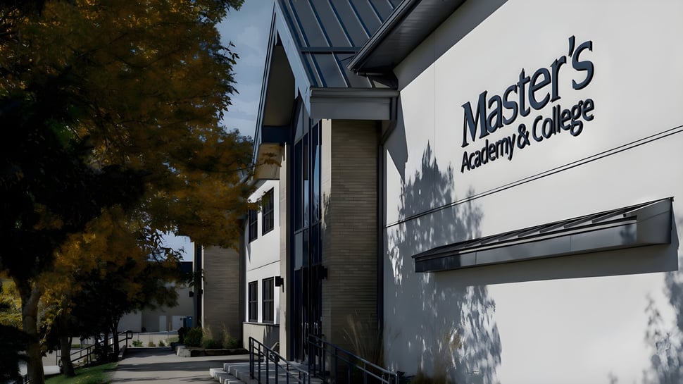 El moderno edificio de la Master's Academy and College está rodeado de árboles y muestra el letrero en la entrada.
