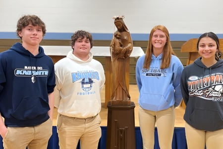 Un grupo de cinco estudiantes está en el gimnasio de la Mater Dei Catholic High School.