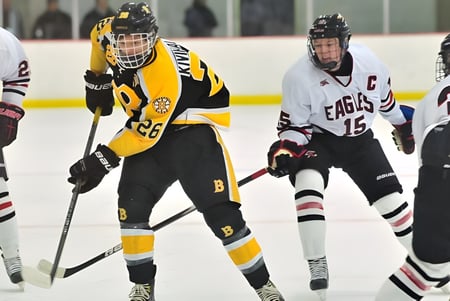 Estudiantes de la Matthew Halton High School juegan un partido de hockey en la pista de hielo frente a espectadores.
