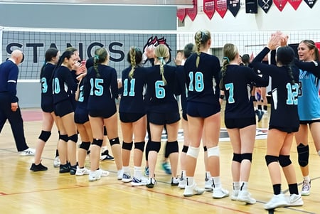 Un grupo de jugadoras de voleibol está en el campo de la Maxwell Heights Secondary School.