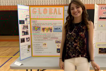 Una estudiante está frente a una presentación sobre el tema Ciudadanía Global en el campus de la Maynard High School.