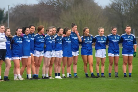 Un grupo de jóvenes futbolistas está en el campo en el campus de la Meán-Scoil Mhuire Gan Smál.