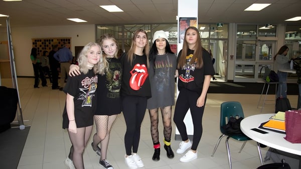 Un grupo de estudiantes de la Medicine Hat High School está en una sala con mesas y sillas.