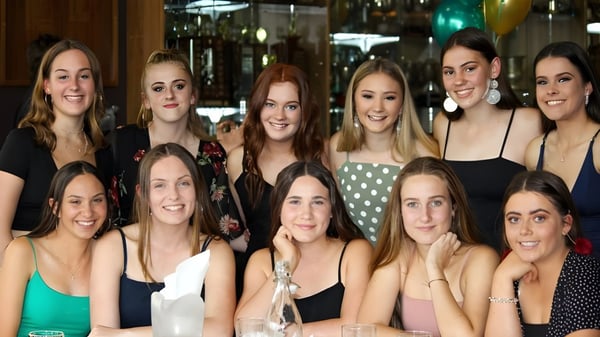 Un grupo de estudiantes de la Melville Senior High School se reúne en una sala decorada festivamente.