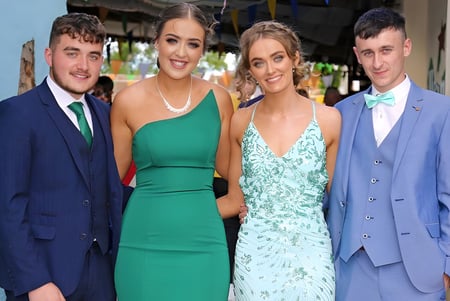 Cuatro personas vestidas de gala posan en un evento de la Mercy Secondary School.