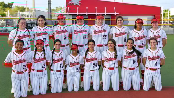 Un grupo de jugadores de béisbol en uniformes blancos y rojos está en el campo de la Miami-Dade County Public School.