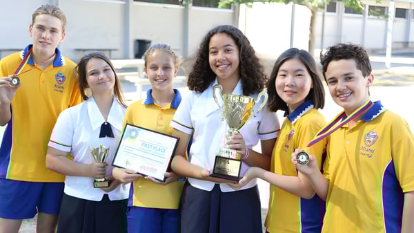 Estudiantes de la Miami State High School celebran con trofeos y diplomas sus éxitos en el entorno escolar.