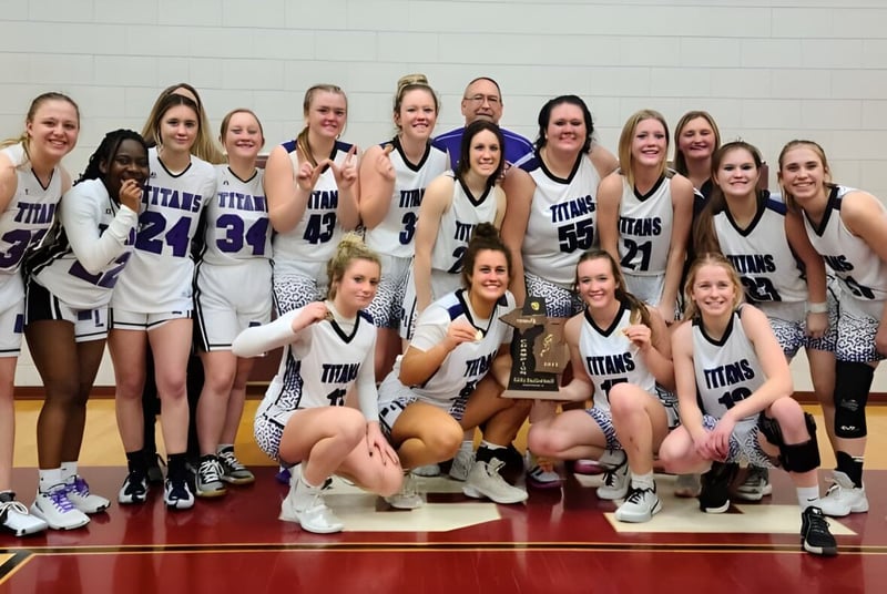 Estudiantes de la Michigan Lutheran High School celebran en la cancha de baloncesto su victoria con un trofeo.