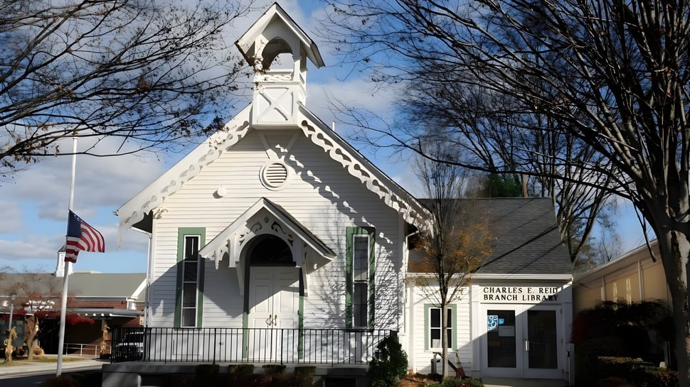 Una iglesia de madera blanca con torre se encuentra frente a un cielo nublado en el terreno de la Midland School.