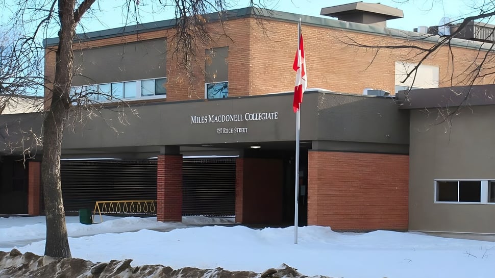 El edificio de ladrillo con la bandera canadiense se encuentra en el terreno nevado del Miles Macdonell Collegiate.