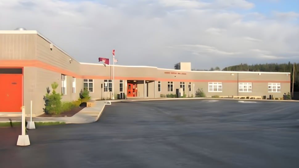 Se puede ver el moderno edificio de varios pisos con puerta de entrada roja y bandera canadiense de la Mobile Central High.