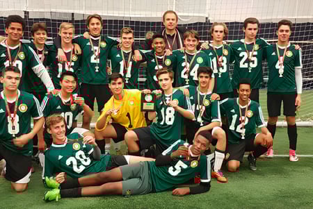 Estudiantes del Monarch Park Collegiate Institute posan juntos en el campo de fútbol frente a la portería.
