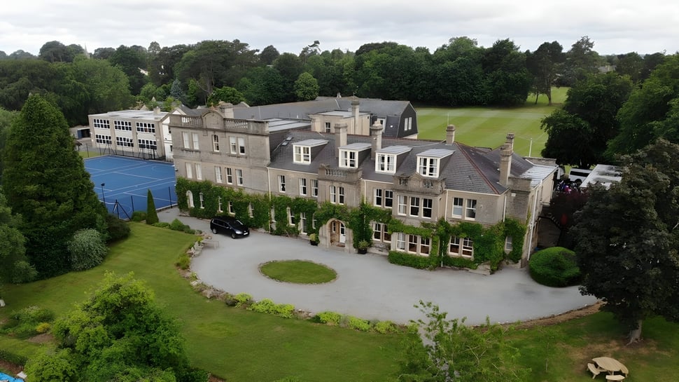 La histórica casa principal de la Monkton Combe School está rodeada de un cuidado verde y un sendero circular.