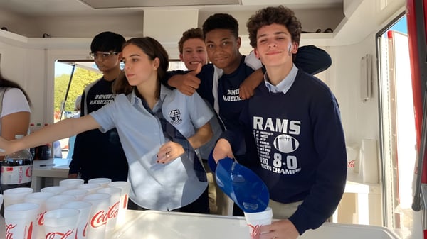 Un grupo de estudiantes de la Monsignor Donovan Catholic High School posando juntos en un entorno de cocina.