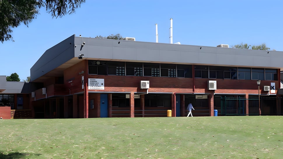 El moderno edificio de ladrillo de la Morley Senior High School se encuentra de varios pisos detrás de un campo verde.