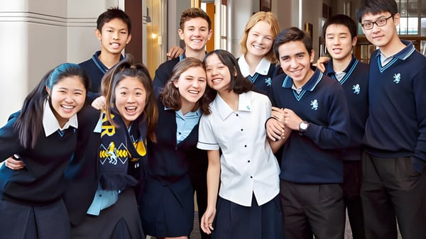 Un grupo de estudiantes en uniformes escolares posan en un pasillo del campus de la Mount Albert Grammar.