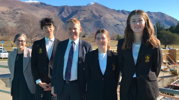Cinco estudiantes están frente a un paisaje montañoso en el terreno del Mount Aspiring College.