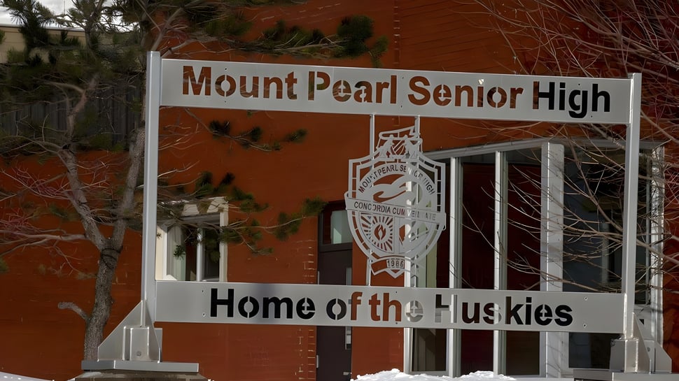 El cartel de indicación con la inscripción Home of the Huskies está frente al edificio de ladrillo de la Mount Pearl Senior High School.