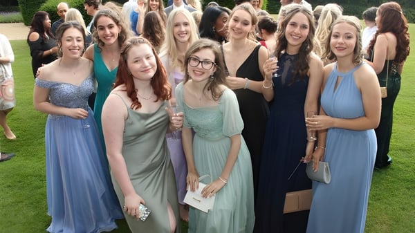 Un grupo de jóvenes mujeres posan sonriendo con ropa formal en el área exterior del Mullingar Community College.