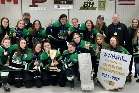 Estudiantes del Murdoch Mackay Collegiate celebran junto con un trofeo su victoria en el campeonato de hockey.
